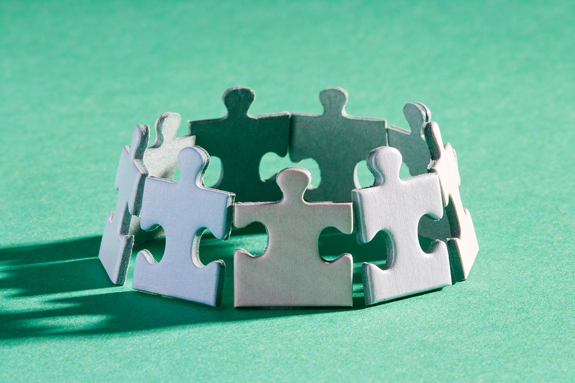 Wooden people figures connected with green lines representing operational alignment